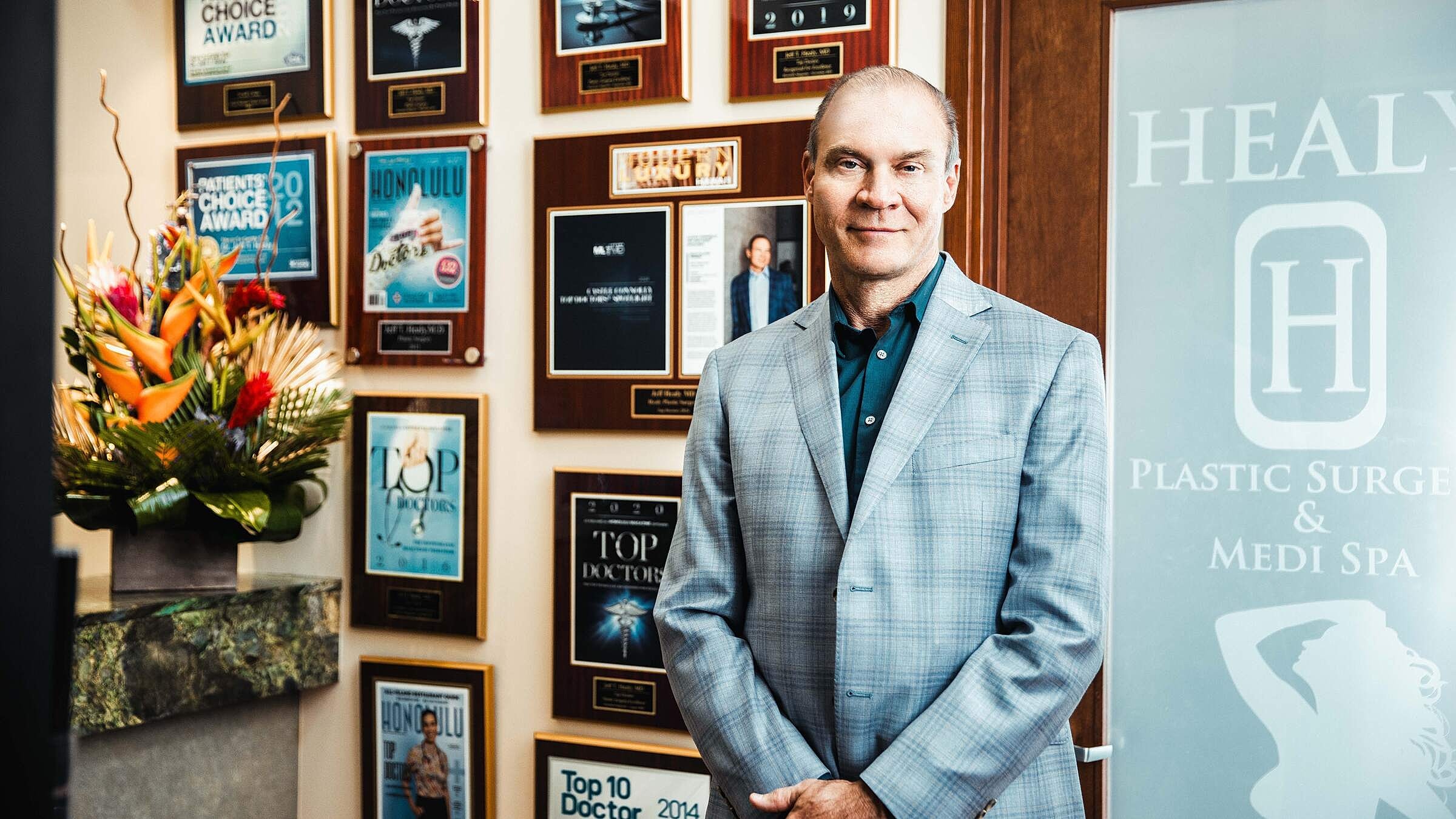 Professional man in front of award displays.
